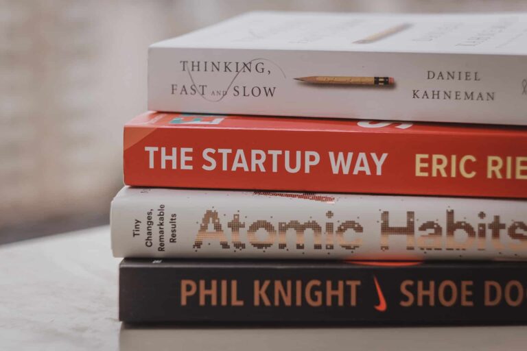 Stack of four books: Thinking, Fast and Slow; The Startup Way; Atomic Habits; Shoe Dog by Phil Knight.